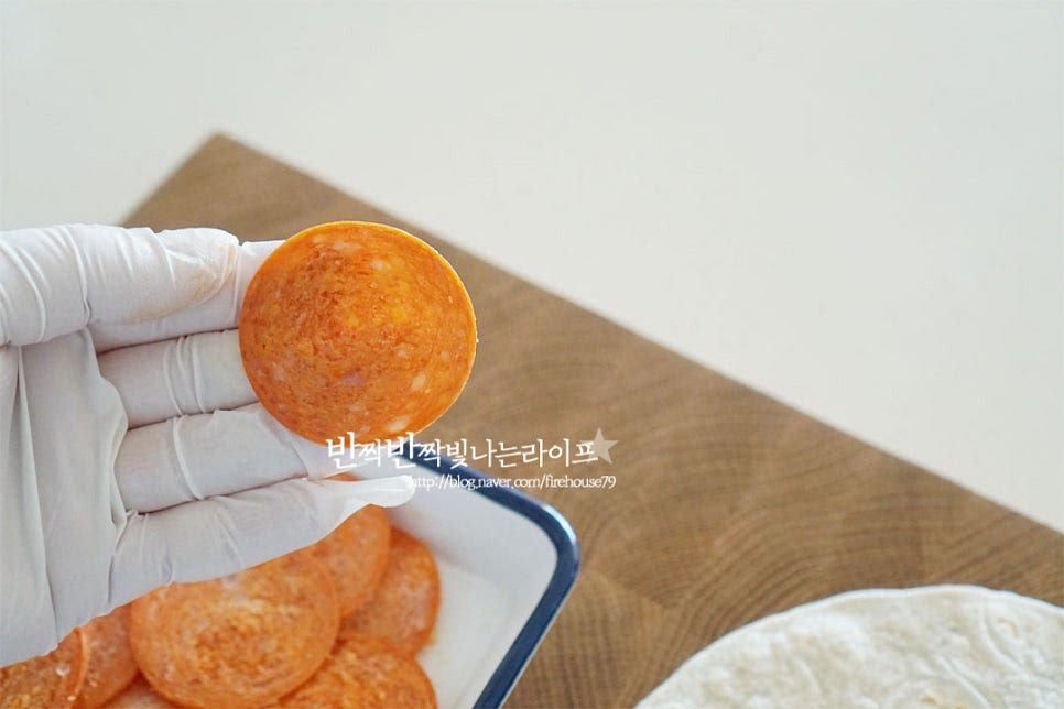 페퍼로니햄은 돼지고기와 소고기에 양념을 하여 만들어 짭조름한 특유의 맛이 피자와 잘 어울리는데요. 담백한 또띠아 도우 + 상큼한 토마토소스 고소한 치즈와 맛있게 어울려요. 간이 있는 편이라 맥주안주로도 좋고요. 끝부분에서부터 동그란 모양을 따라 하나씩 돌려가며 올려줍니다. 구워지면서 크기가 수축되기 때문에 빼곡하게 토핑을 해주면 더욱 먹음직스럽습니다. 기본 레시피인 페퍼로니만 넣어주었는데 파인애플, 피망, 올리브 등 좋아하는 재료들을 곁들여도 좋아요.