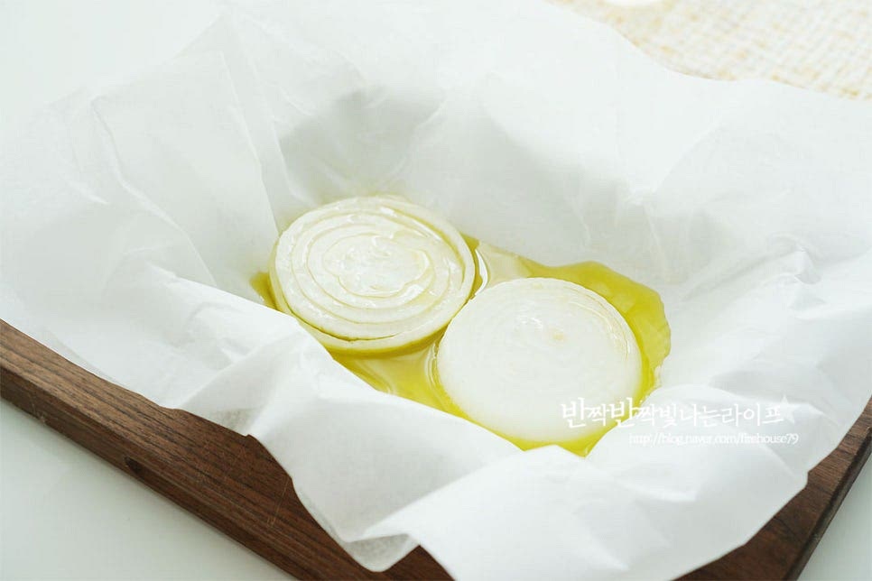 종이 포일을 큼직하게 잘라준 뒤 올리브오일을 자작하게 두르고 양파 슬라이스를 올려줍니다. 포일을 넉넉하게 준비해 주어야 손질한 재료를 모두 담아 파피요트 모양을 만들 수 있어요. 양파 위에 필렛을 올리고 소금, 후추 약간 간을 하고 하드치즈(파마산)을 갈아줍니다. 양파 위에 올려서 구워주면 맛이 어우러짐이 좋고, 치즈를 약간 갈아 넣어주면 고소한 풍미도 살아요. 편으로 썰어둔 마늘도 올려주고요. 조개와 새우도 같이 곁들여요. 아스파라거스, 양송이버섯도 다른 재료들과 어우러지도록 올려요. 방울토마토, 레몬 허브(딜)을 올려줍니다. 허브는 로즈마리나 바질 등 입맛에 맞게 넣어줍니다. 화이트 와인 20ml 정도 가장자리로 둘러 뿌려줍니다. 다시 끔 올리브오일을 뿌려줍니다. 재료가 어우러질 정도로 2 큰 술 정도를 둘러 뿌려주었어요. 종이 포일을 감싸줍니다. 마무리 끝부분을 바닥면에 향하게 하여 고정을 하여주었어요.