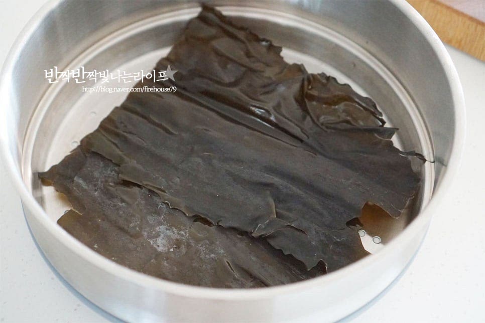 준비한 재료를 찜기에 담아줍니다. 먼저 바닥에 다시마를 깔아주는데요. 냄비 크기에 따라 크기를 조절해 주세요. 다시마는 흐르는 물에 헹군 뒤 올려주세요. 전복이 다시마나 미역을 먹기 때문에 다시마와 찌면 본연의 감칠맛이 더 좋습니다. 그 위로 손질한 재료를 올려줍니다. 무를 올려 덮어줍니다.