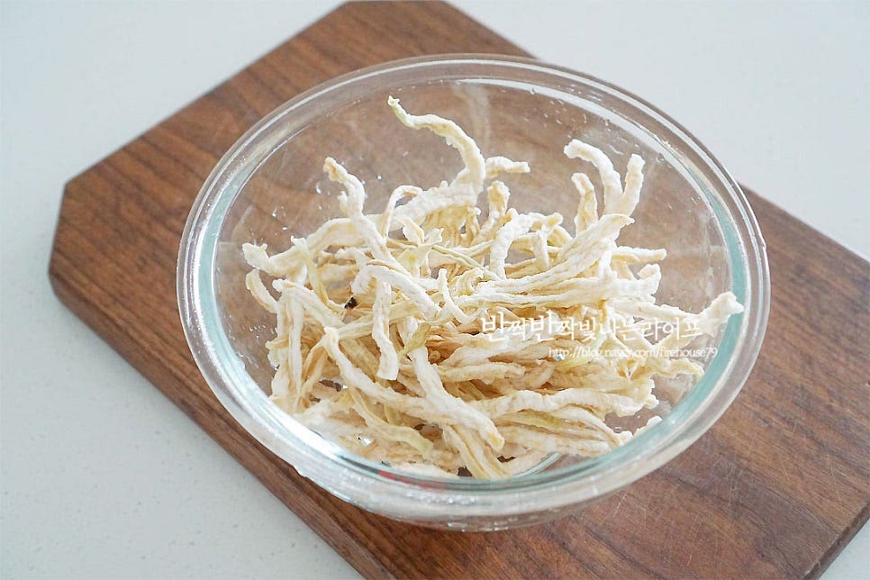 건조된 무우말랭이를 준비했어요. 생으로 무쳐먹는 맛도 좋지만 말린 것만의 식감과 달큰함이 매력이죠. 흐르는 물에 두세 번 가볍게 헹구어 먼지나 잔가루를 제거해 줍니다. 잠길 정도 물을 붓고 20~30분 정도 불려줍니다. 불리는 시간은 수분 상태에 따라 중간 체크를 하여 가감해 주시면 되는데요. 너무 많이 불려도 식감과 맛이 싱거워지니 중간에 식감을 확인하여 불려주시는 게 가장 좋아요. 딱딱하지 않으면서도 너무 물컹하지 않은 꼬들한 상태가 적당해요. 저는 20분 정도 불린 뒤 흔들어 씻어 주었어요. 깨끗하게 헹구어 준 뒤 물기를 꼭 짜서 준비해 줍니다. 생각보다 불리고 나면 양이 꽤 많아진답니다. 처음에 불리기 전에 양이 적어 보여도 이 정도 만들어 두면 꽤 든든해요.
