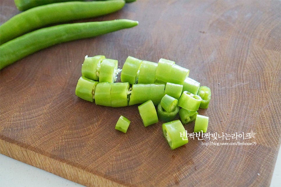 세척 손질하여 물기를 제거한 오이고추는 먹기좋게 썰어줍니다. 양 끝 부분은 잘라내어주고 한입 크기로 1.5~2cm 정도로 썰어줍니다. 가운데 씨가 너무 많은 부분은 살짝 흔들어 털어주면 깔끔하게 먹기 좋습니다. 어느 정도 아삭한 식감이 느껴지도록 큼직하게 썰어주는데요. 연하고 부드러워서 통으로 만들어 먹기도 한답니다. 아래 사진과 같이 사이로 양념이 들어가 어우러질 수 있도록 썰어주면 됩니다.