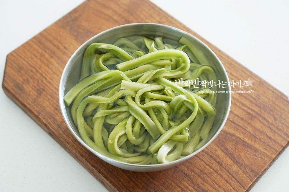 입맛에 따라 설탕, 식초를 가감해주세요. 하나, 건 궁채를 미리 서너 시간 불려 준비했어요. 건조된 상태에서 보면 양이 얼마 되지 않는 것 같지만 불려보면 양이 꽤 많아요. 건조된 것은 바락바락 문질러 여러 번 씻어주셔야 특유의 냄새를 제거할 수 있어요. 줄기상추라는 이름 그대로 상추대를 말린 것인데 생각보다 쾌쾌한 냄새가 나서 깨끗하게 씻어준 뒤 물에 불려주시는 게 좋아요. 참고로 중국산이라 마트보다는 온라인몰에서 더 구입이 쉽습니다. 깨끗하게 씻어 불려두면 오동통한 초록 색감이 선명해져요. 양이 3배 이상은 불리는 것 같아요~ 다시 한번 물에 헹구어준 뒤 물기를 꼭 짜줍니다. 길이가 길기 때문에 모양을 가지런히 잡아 한입에 먹기 좋게 썰어주시면 됩니다. 끝부분은 조금 잘라내고 5~6cm 길이로 일정하게 잘라줍니다. 취향껏 먹기 좋은 길이로 잘라주시면 되어요. 매콤한 색감을 더해주기 위해 홍고추도 큼직하게 썰어 넣었어요. 고추는 기호에 따라 넣어주시면 됩니다. 먹기 좋게 손질한 재료를 밀폐용기에 담아줍니다.