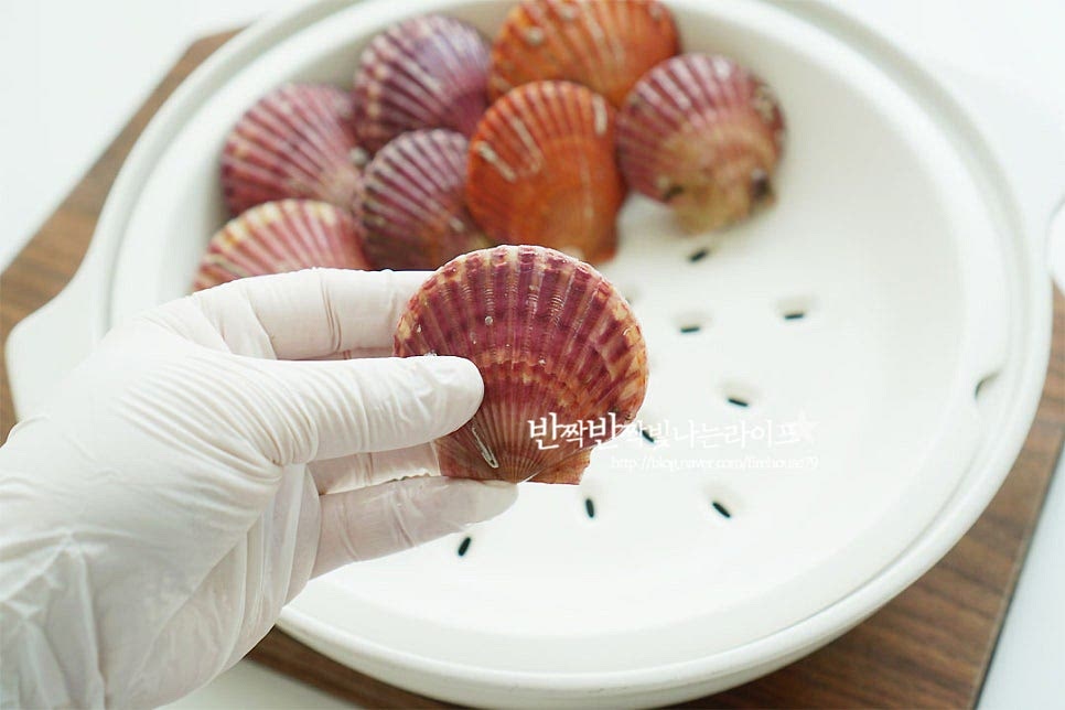 손질한 뒤 쪄서 먹거나 삶아서 먹음 되어요. 특유의 맛을 살려주기 위해 저는 찜기에 쪄주었어요. 물을 살짝 잠길 정도로 넣은 뒤 15분 정도 삶아 드셔도 됩니다^^ 가리비 찌는법 소소한 포인트로 먼저 찜기에 담아줄 때는 입 부분이 위로 향하게 세워서 담아줍니다. 그럼 하나씩 집어서 먹기도 좋을뿐더러 바다맛이 흘러내리지않아 더 깊고 진한 맛을 느낄 수 있어요~ 찜기에 세워서 담아주었어요. 삶을 때도 세워서 담아 삶아주어요~ 냄비에 물 400~500ml 정도 부은 뒤 생강술 또는 청주 2큰술 넣어줍니다. 청주를 넣고 삶으면 비린내를 잡아줄 수 있어요. 찜기가 끓어오르면 재료를 올려 10~15분 정도 쪄줍니다. 너무 오래 쪄주어도 식감이 오히려 질겨져 버리니 재료의 양에 따라 시간은 조절해 주어요. 대략 12분 정도 쪄준 뒤 5분 뜸을 들여주었어요. 뚜껑을 열어보면 바다향과 함께 모두 입을 벌리고 탱글탱글한 조갯살을 품고 있답니다^^