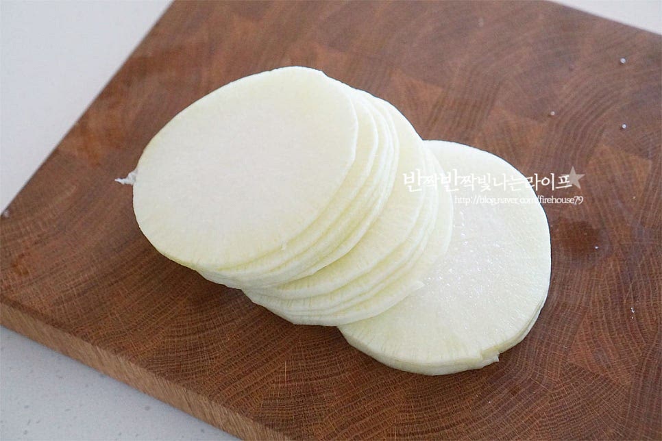 무는 일정한 두께로 채를 썰어줍니다. 단맛이 풍부한 무청이 있는 초록 부분을 껍질을 벗겨 준비했는데 여름으로 갈수록 무의 쓴맛이 강해지므로 간을 할 때 설탕을 조금 넣어 달큰하게 볶아주는 게 좋아요. 아직은 달고 맛이 좋아 나물반찬하면 맛있어요. 편으로 먼저 썰어줍니다. 일정하며 곱게 채를 썰어줘야 부서지지 않고 골고루 익어요. 2~3mm 두께로 채썰어줍니다. 너무 두꺼워도 익히는데 시간이 걸리고 얇아도 부서지기 쉬워요.