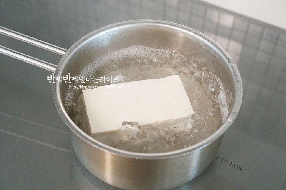 꼬마 사이즈로 만들어 두부 1/2 모를 준비했어요. 바로 으깨어 요리하게 되면 물이 생기기 쉽기 때문에 데친 뒤 물기를 꼭 짜줄 것입니다. 먼저 끓는 물에 두부를 넣고 3~4분 데쳐줍니다. 면포에 올려 가볍게 한 김 식힌 뒤 물기를 꼭 짜줍니다. 수분을 짜면 포슬포슬 부드러워요. 전처리 한 뒤 유부초밥 속을 채워야 고소한 풍미는 더 풍부하고 물이 생기지 않습니다.