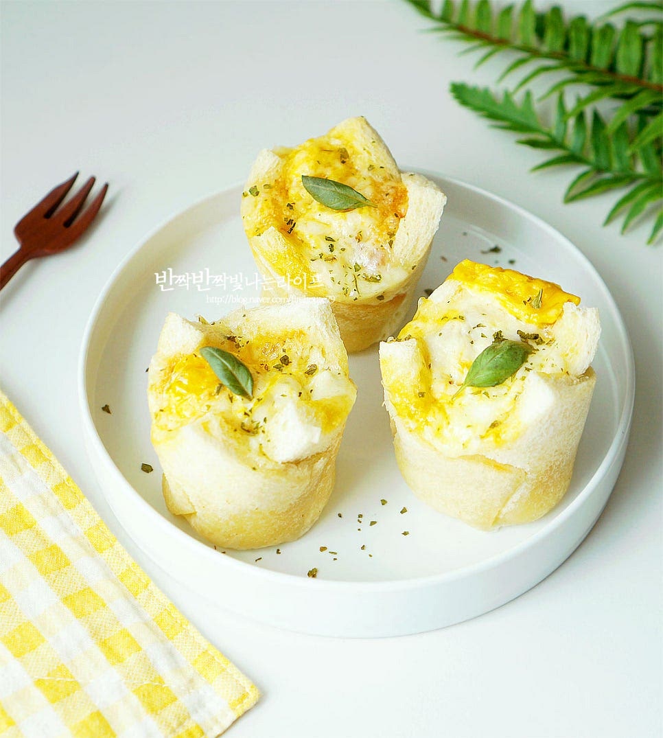 뜨거울 때 바로 먹어야 치즈가 쭉 늘어나고 따뜻하고 담백 고소합니다. 완성된 계란빵은 접시에 담아줍니다. 머핀 같으면서도 촉촉하게 익은 달걀과 식빵의 고소한 맛이 맛있게 어우러집니다. 재료를 넣고 조리해 주면 되는 초간단 레시피로 만들 수 있으며 계란 1개씩 들어가 하나만 먹어도 푸짐하죠. 전자레인지 종이컵 계란빵 만들기 맛있게 완성하기도 좋고 아이들 간식으로 든든합니다. 쉽고 간단한 영양간식 간단하고 맛있게 만들어드세요. 끄읕 !