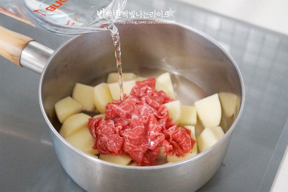 깊은 프라이팬 또는 냄비에 손질한 재료를 넣고 감자조림을 만들어 줄 것인데요. 큼직한 감자와 소고기를 먼저 담은 뒤 물 2⅔ 컵을 부어줍니다. 물은 재료가 자작하게 잠기는 정도로 잡아주세요.