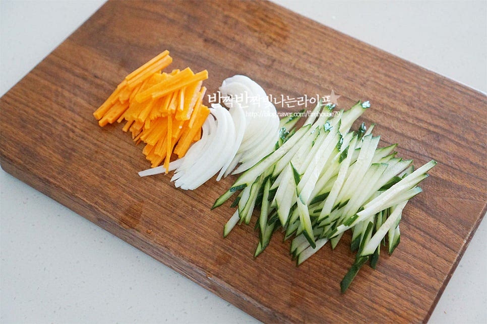 오이는 굵은소금으로 씻은 뒤 곱게 채를 썰어주고, 양파와 당근도 밸런스를 맞추어 채 썰어요. 입맛에 따라 깻잎이나 양배추 등을 넣어도 좋습니다. 비빔국수같이 아삭한 식감을 더해주는 야채가 들어가면 오독오독한 맛과 잘 어울린답니다.