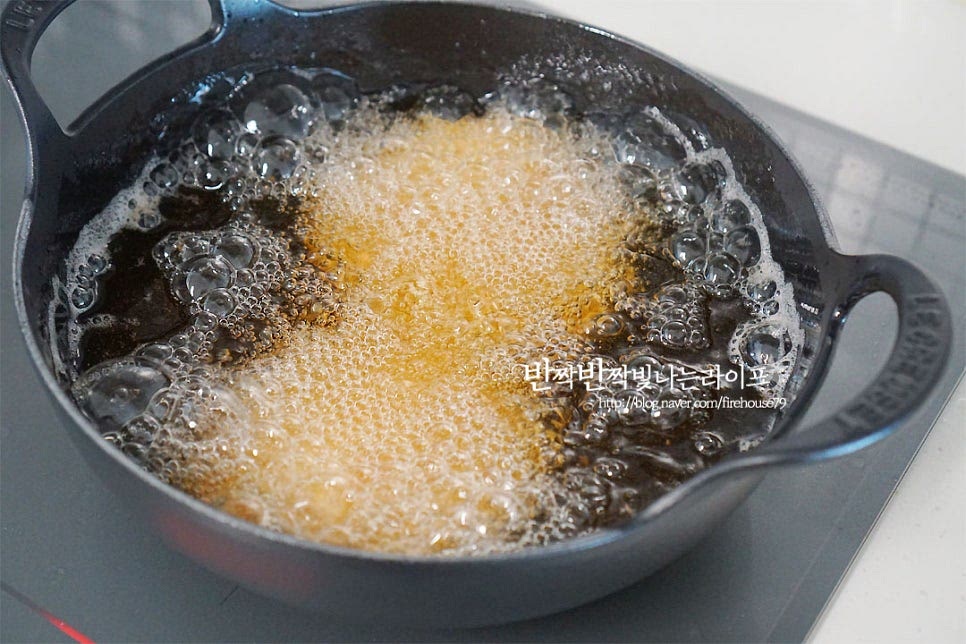 팬에 기름을 넉넉히 두르고 돈까스를 바삭바삭하게 튀겨줍니다. 에어프라이어로 조리해 주셔도 좋아요. 냄비에 넣고 한 번 더 익혀줄 것이라 완전히 속까지 익지 않아도 걱정 마세요. 겉의 튀김옷을 바삭하게 튀겨주시면 됩니다. 망에 올려 기름을 빼줍니다. 먹기 좋게 길게 잘라 준비해두어요.