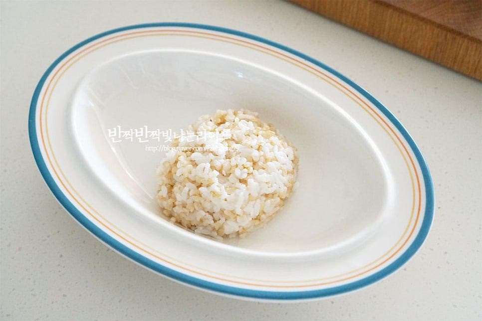 깊은 그릇에 현미밥 1/2공기를 담아줍니다. 가볍게 먹기 위해 밥은 줄이고 채소를 넉넉하게 넣어 포만감을 더해줍니다. 그 위로 오이와 어린잎, 양파 기름 뺀 참치를 올립니다. 그 위로 달걀을 올려 푸짐하게 담아줍니다. 만들어둔 간장소스를 부어 완성합니다. 간에 따라 적당량을 곁들입니다.