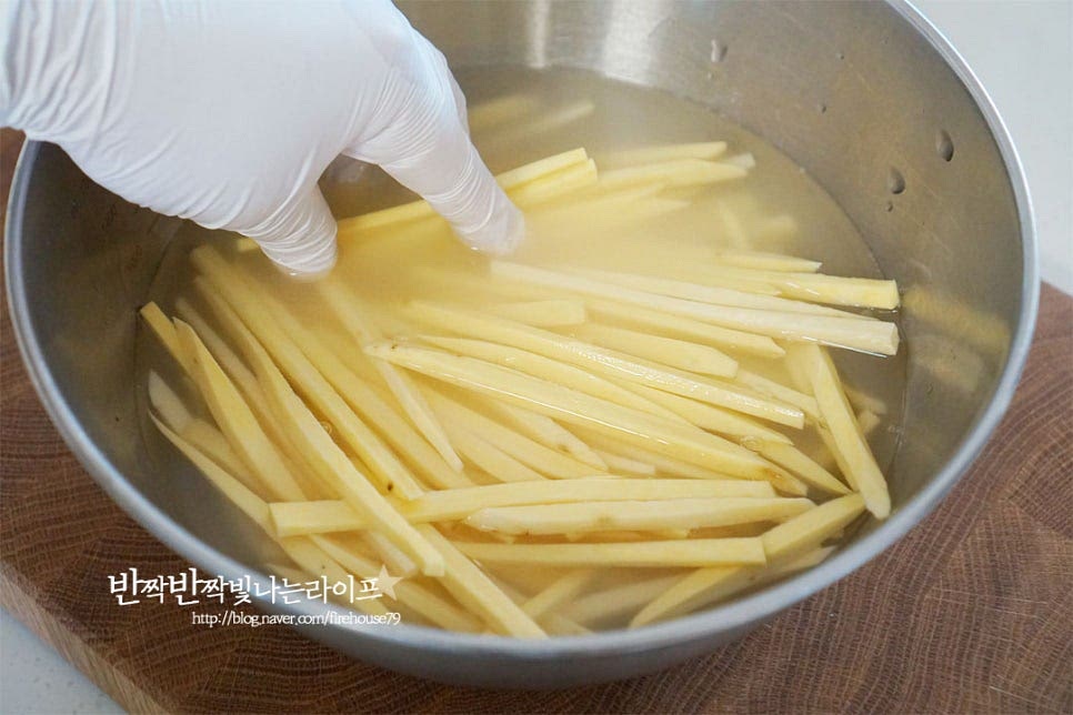 넉넉한 크기의 볼에 채 썬 재료와 충분하게 잠길 정도로 물을 붓고 살살 흔들어가며 전분을 제거해 줍니다. 물에 담그면 뽀얗게 전분이 나오는데요. 이걸 제거해 주어야 식감이 내내 바삭하답니다. 네다섯 번 헹구어 주거나 5분 정도 물에 담가 제거해 줍니다. 이때 너무 오래 물에 담그면 되려 단맛이 빠져 싱거워질 수 있으며 단맛이 적은 것은 설탕을 녹여 담가주어도 좋습니다. 바삭한 고구마스틱을 만들기 위해 전분과 함께 물기도 모두 제거해 줍니다. 물기 없이 튀겨 익혀주어야 맛이 좋습니다.