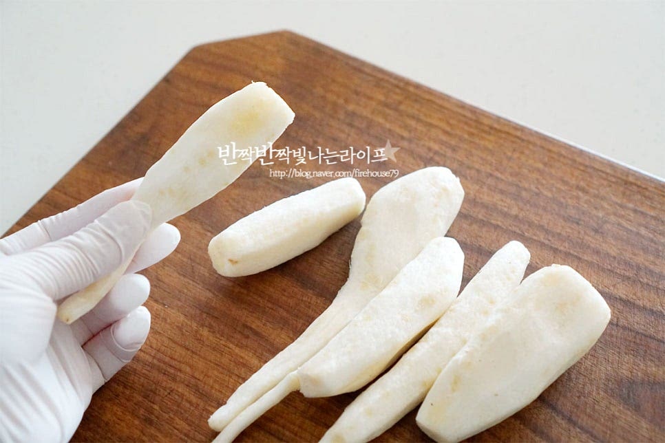 먹기 좋게 껍질이 벗겨진 더덕을 준비했어요. 껍질이 있는 상태라면 솔로 문질러 흙을 씻어낸 뒤 팔팔 끓는 뜨거울 물을 부었다가 꺼내어 머리 부분을 잘라내고 결 방향대로 껍질을 벗겨주시면 됩니다. 향긋한 향이 진한만큼 사포닌 특유의 쌉싸래한 맛이 있는데요. 옅은 소금물에 담가주면 쓴맛을 잡아줄 수 있어요. 보통 자연산 같은 경우 향이 진하지만 재배된 것은 향이 강한 편이 아니기도 하고 사포닌 성분이 물에 잘 녹기 때문에 오래 담그지 않아도 됩니다. 물기를 제거하여 준 뒤 크기가 큰 것은 2~3등분 하여 줍니다. 식감을 조금 더 부드럽게 해주기 위해 가볍게 두드려 주거나 밀대로 밀어주시면 됩니다. 힘을 강하게 주면 부서질 수 있으니 살살 두드려 주었어요.