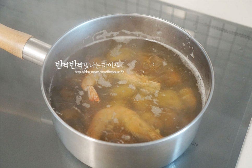 육수를 넣고 끓이다가 끓어오르면 바지락 조개와 새우를 넣어줍니다. 바지락이 입을 벌리기 시작하고 국물이 끓어오르면 칼국수면을 넣어줍니다. 면에 묻어있는 가루를 털어내기 위해 체에 그대로 올려준 뒤 흐르는 물에 헹구어줍니다. 면을 헹군 뒤 넣어주면 국물이 탁하지 않고 깔끔합니다. 면을 넣고 억지로 풀려고 하면 되려 끊어지기 쉬우므로 끓으면 젓가락으로 살살 풀어가며 뭉치지 않고 눌어붙지 않게 끓여줍니다.