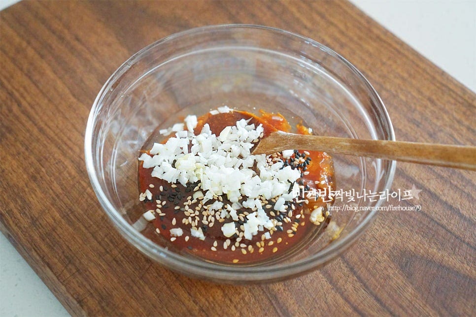 더덕구이 양념을 준비해요. 고추장 2 큰 술, 황설탕 2/3 큰 술 진간장 1/2 큰 술, 꿀 1 큰 술 조청 또는 물엿 1 큰 술, 참기름 1/2 큰 술 다진 마늘 1 작은 술, 다진 대파 1 큰 술 검은깨 약간 넣어줍니다. 재료가 어우러지도록 잘 섞어줍니다. 매콤하면서도 달짝지근하게 만들어주면 밑간해둔 더덕과 간이 잘 어우러지니 간을 보고 입맛에 맞게 조절해 주세요. 곁들여 먹을 쪽파는 송송 썰어 준비해둡니다.