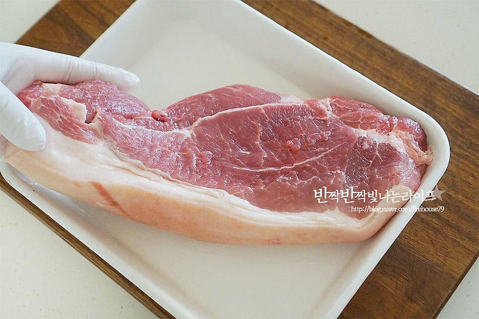 돼지 앞다리살을 준비했어요. 삼겹, 오겹살, 목살 등 부위는 기호에 맞게 준비해 주세요. 앞다리살로 수육을 삶았을 때 비계 껍질 부분이 쫄깃하여 식감이 좋은데요. 부담 없이 즐기기 좋은 부위입니다. 크기에 따라 너무 큰 것은 2~3등분으로 잘라준 뒤 가볍게 헹구어 물기를 제거해 줍니다. 된장 1 큰 술 듬뿍 퍼서 골고루 발라주어요. 돼지수육 삶을 때 누린내도 잡고 맛있게 간이 스며들 수 있게 해주는 된장은 빠질 수 없는 재료랍니다~