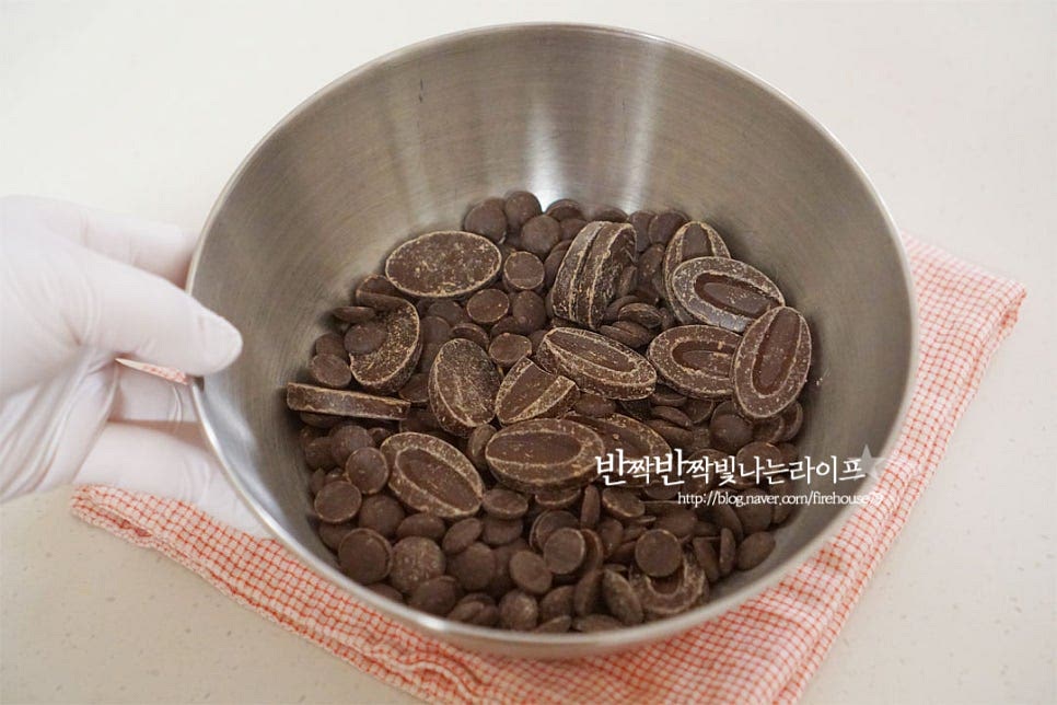 넉넉한 크기의 볼에 초코를 넣어줍니다. 다크 한 가지로 만 만들어도 되지만 밀크를 약간 섞어 만들면 조금 더 부드러운 풍미를 맛볼 수 있습니다. 크기에 따라 큰 덩어리는 녹기 쉽게 작게 다져 썰어주세요. 저는 칼리바우드와 발로나 두가지 섞었습니다. 뜨거운 물에 볼을 올리고 중탕으로 녹여줍니다. 중탕하는 과정에서 중요한 것은 물이 들어가지않도록 해주는 것입니다. 물이 들어가면 굳지않을 수 있습니다. 끓는 물로 녹이게되면 김이 서려 물이 들어갈 수 있으니 적당하게 뜨거운 정도의 물이 좋습니다. 주걱으로 가볍게 저어 녹여줍니다.