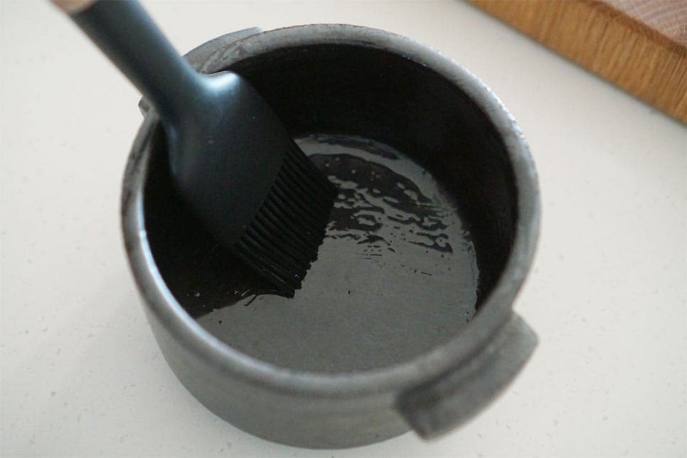 전자레인지 사용이 가능한 뚝배기를 준비했어요. 눌어붙지 않고 고소한 풍미를 더해줄 수 있도록 참기름을 약간 넣고 전체적으로 코팅해 줍니다. 만들어둔 달걀물을 부어줍니다.