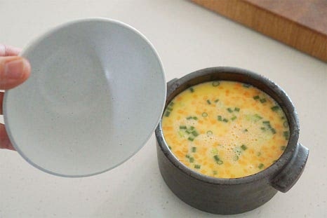 볼록한 밥공기를 뚜껑 대신 덮어줍니다. 평평하게 랩을 씌워도 되지만 위쪽의 공간에 뜨거운 열기를 채울 수 있도록 봉긋하게 덮어주면 더 촉촉하고 부드러워요. 뚜껑을 덮은 뒤 전자레인지에 넣고 3분 먼저 조리해줍니다. 3분 조리한 뒤 2분 추가로 더 익혀줍니다. 출력에 따라 시간은 차이가 날 수 있는데 대략 5~6분 조리해주면 보들보들 속까지 익어요. 양이 많을 때는 중간에 겉과 속이 섞이도록 가볍게 젓고 다시 조리해주셔도 좋습니다. 속까지 몽글몽글 잘 익었어요. 익은 정도를 확인하고 싶다면 나무 꼬치로 찔러보았을 때 달걀물이 묻어나지 않으면 잘 익은 것이에요.