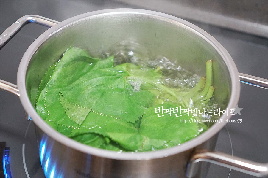 끓는 물에 소금을 넣고 곰취를 데쳐주세요. 그리고 채반에 받쳐 물기를 제거해 주세요. 잎이 얇기 때문에 손으로 꼬옥 짜다가 잎이 찢어질 수도 있어요.