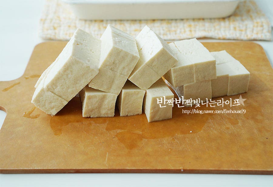 두부는 주사위 모양으로 정사각형 썰기를 하여 줍니다. 한입에 먹기 좋은 크기로 잘라주어요. 자른 뒤 소금과 후추를 약간 뿌려 밑간을 하여줍니다. 그리고 키친타월로 물기를 제거해요. 물기가 많으면 기름에 넣었을 때 사방으로 튀어 오를 수 있으니 꼼꼼하게 물기를 흡수해 줍니다.