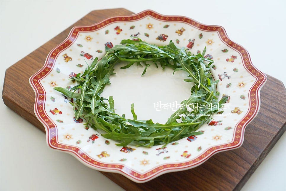 루꼴라를 가장자리로 동그란 리스 모양으로 담아줍니다. 샐러드 채소는 그 외 어린잎이나 바질 등 다양하게 준비하셔도 좋습니다^^ 토마토는 색감을 살려 중간중간 담아줍니다. 사이로 치즈를 올려줍니다. 리스샐러드에 연말 분위기를 더해주고 싶어 가운데 루돌프 모양을 만들어 같이 플레이팅해주었어요. 만들기 정말 간단하죠~ 영상을 같이 보시면 보다 쉽게 만들어 드실 수 있답니다. 동그란 루꼴라 리스샐러드에 색깔 고운 재료를 올려 담으면 크리스마스 분위기도 내고 맛있게 입맛 돋우는 샐러드를 맛볼 수 있어요. 크리스마스엔 맛도 좋고 모양도 예쁜 토마토 샐러드 어떠세요. 재료의 맛을 살려 간단하게 만들고 보기 좋게 플레이팅해주면 캐럴이 절로 흥얼거려진답니다. 즐거운 연말 준비하세요^^ 끄읕 !