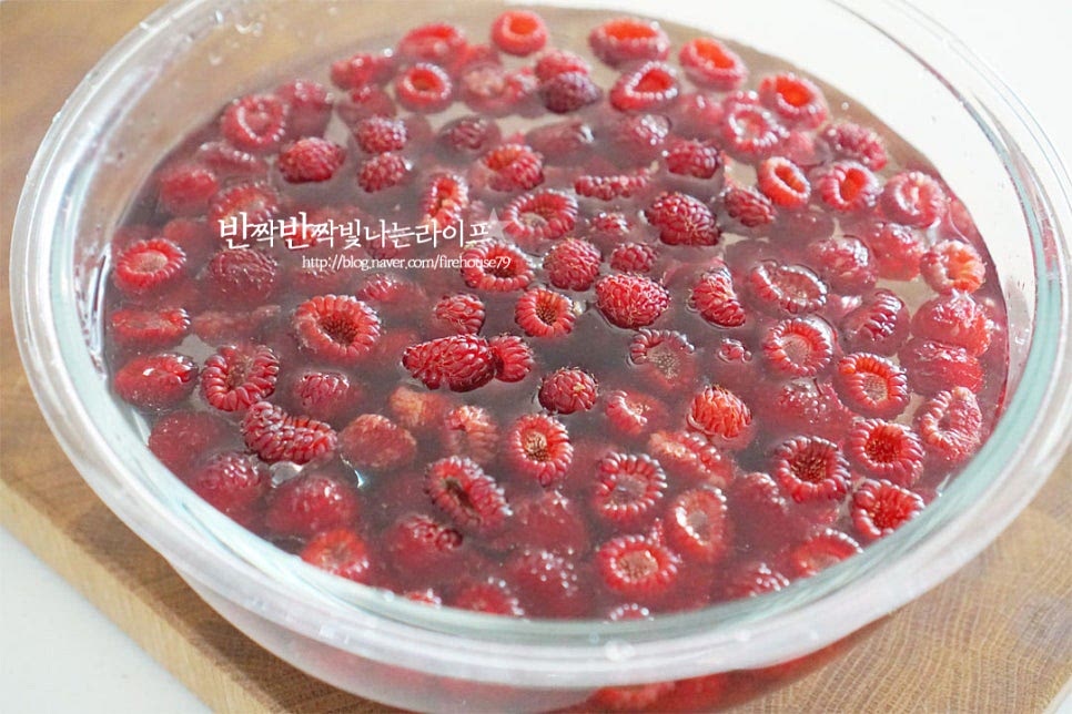 넉넉한 크기의 볼에 잠길 정도로 물을 붓고 식초 1 큰 술 또는 베이킹소다를 풀어 산딸기를 담가 살랑살랑 흔들어줍니다. 물에 오래 담그면 단맛이 빠지고 비타민C도 물에 녹아 빠져나오기 때문에 30초 이상 담그지 않는 것이 좋습니다. 식초물에서 건져내어 흐르는 물에 헹군 뒤 체에 밭쳐 물기를 털어줍니다. 과육 사이 안의 불순물을 꼼꼼하게 헹구고 물기를 제거해 주면 됩니다.