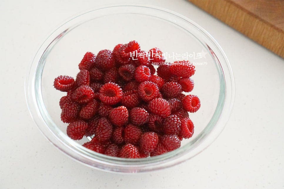 세척 손질한 산딸기를 담아줍니다. 과일청의 설탕 비율은 1:1로 보관 기간에 따라 설탕량을 조절해 주는데요. 저는 설탕과 알룰로스를 함께 넣어주었습니다. 설탕 0.7 : 알룰로스 0.3으로 레몬을 넣어 단맛을 조절했어요. 재료가 어우러지도록 섞어줍니다. 버무리는 과정에서 자연스럽게 으깨어주세요. 레몬을 넣고 함께 섞어줍니다. 실온에서 설탕이 녹을 수 있도록 저어주었다가 녹으면 열탕소독한 유리병에 담아 냉장고에서 일주일 이상 숙성해 줍니다. 보관할 병은 열탕소독하여 물기 없이 건조해서 보관해 주세요.