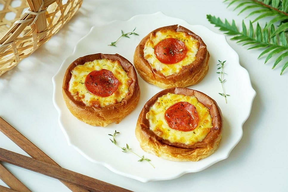 모닝빵으로 만든 시카고피자 완성입니다. 치즈가 굳지 않게 뜨거울 때 먹어야 맛있어요. 바로 먹으면 바삭한 빵 안으로 치즈가 쭉 늘어나며 새콤달콤한 토마토소스와 짭조름한 페퍼로니가 맛있게 어우러진답니다. 집에서 피자만들기 레시피 중에서도 담백한 모닝빵으로 만들어 맛이 잘 어울리며 만들기 간단해서 아이들 간식이나 출출할 때 야식으로 먹기도 좋아요. 영상도 같이 담았어요. 신랑은 햄을 좋아해서 페퍼로니를 더 올려서 만들어주었는데 짭조름한 감칠맛과 토마토소스, 고소한 풍미를 맛볼 수 있었어요. 도우로 토핑을 올리기 좋도록 컵으로 모양을 만들어 재료를 넣고 에프로 구워주면 완성이라 간단하고요. 누구나 좋아하는 간단한 간식으로 맛있게 만들어드세요. 끄읕 !