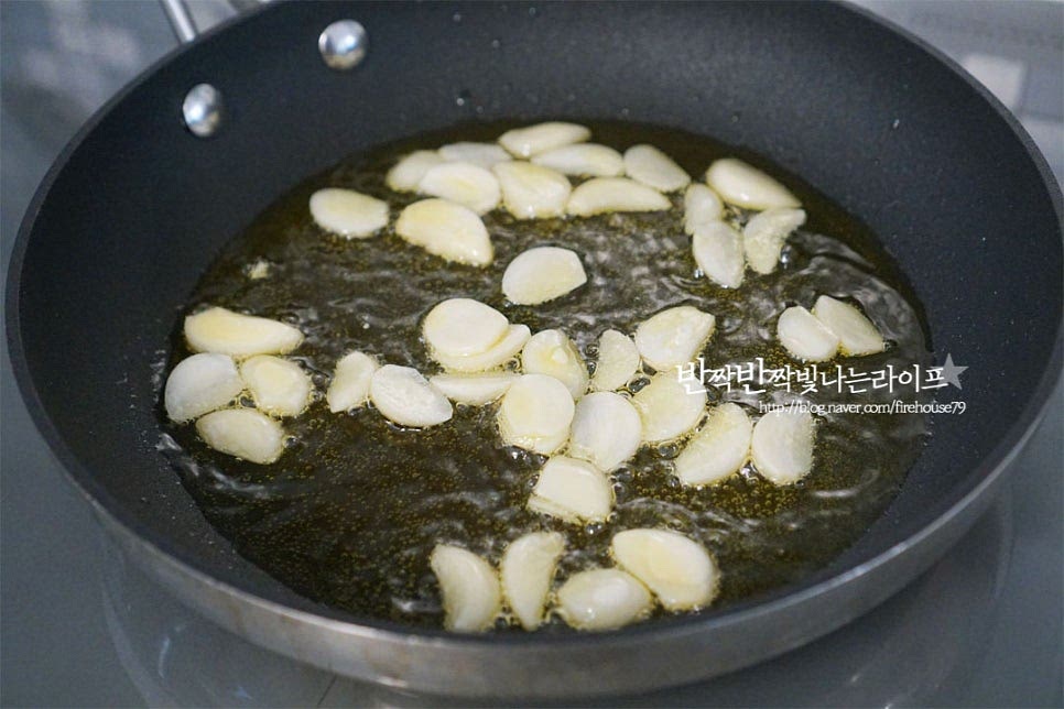 달군 팬에 올리브오일 4~5 큰 술을 두르고 마늘을 넣고 향을 내어줍니다. 오일이 주재료인 만큼 향미 좋을 것을 사용하면 맛있고 마늘은 타기 쉽기 때문에 약불에서 향이 우러나도록 충분히 볶아줍니다. 마늘이 지글지글 소리가 나면 페페론치노도 함께 넣어줍니다. 마늘이 노릇하게 향이 올라오면 면수 60ml 정도를 부어줍니다. 오일과 면수가 섞이면서 알리오올리오 소스가 만들어집니다. 면수와 오일이 어우러지도록 두 가지 재료를 섞어줍니다. 촉촉하게 스며들 정도로 농도를 맞추는데 화력이나 재료에 따라 면수는 조절해 넣어주세요.