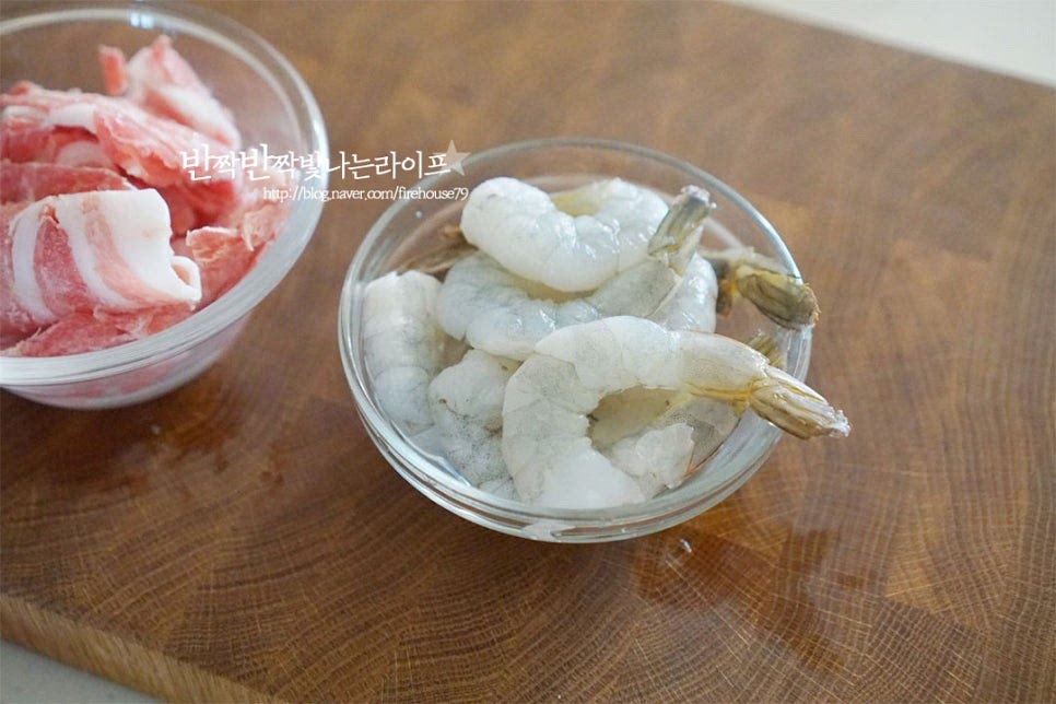 새우는 냉동 손질된 것을 해동하여 준비하고, 돼지고기 소분해둔 것이 조금 남아서 함께 넣었습니다. 오징어나 조개류 같은 해물도 좋고, 소고기나 돼지고기를 얇게 썰어 넣어도 별미입니다. 야채 종류는 양배추를 비롯한 여러 가지를 넣어 만들 수 있습니다. 파기름을 내어줄 양배추는 송송 썰어주고 양파와 당근, 양배추는 채 썰어줍니다. 양배추는 익으면서 줄어들기 때문에 아삭하게 먹는 맛이 있게 조금 큼직하게 자르고 당근은 얇게 썰었습니다. 홍고추는 어슷하게 썰어주고요. 매콤하게 먹고 싶다면 청양이나 마른 고추를 곁들여도 좋습니다.