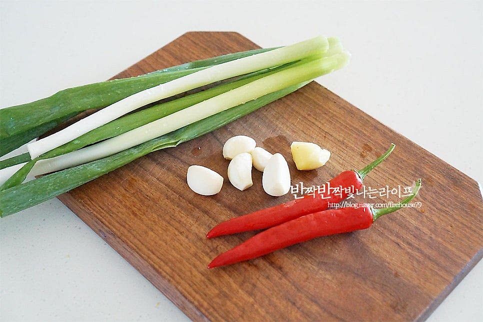 곁들이는 채소로 대파와 홍고추, 마늘과 생강을 준비합니다. 쪽파가 없어 대파를 넣어주었습니다. 마늘과 생강은 채를 썰어줍니다. 나중에 국물에 바로 넣어주시면 되는데요. 저는 아이랑 같이 먹기도 하고, 채 썬 향신채소가 먹기에 불편해서 망에 담아 넣어주었습니다. 홍고추는 씨를 제거하고 곱게 채를 썰어주고, 대파는 3cm 길이로 썰어줍니다.