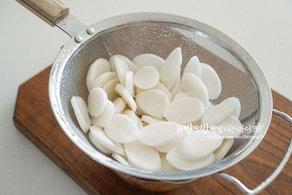 떡국떡은 체에 밭쳐 흐르는 물에 가볍게 헹구어 준비해요. 만두는 시판용 냉동만두를 준비했습니다. 크기에 따라 양은 가감하여 주세요. 달걀을 곱게 풀어 준비해둡니다. 미리 곱게 풀어서 넣어주면 식감이 부들부들하여 텁텁하지 않고 맛이 좋아요. 대파는 송송 썰어줍니다. 냄비에 물 1L를 붓고 다시팩을 넣고 깔끔한 멸치육수를 내어줍니다. 다시 팩을 활용하셔도 좋고, 코인 육수나 멸치와 다시마, 무, 대파를 넣고 직접 육수를 우리셔도 좋습니다.