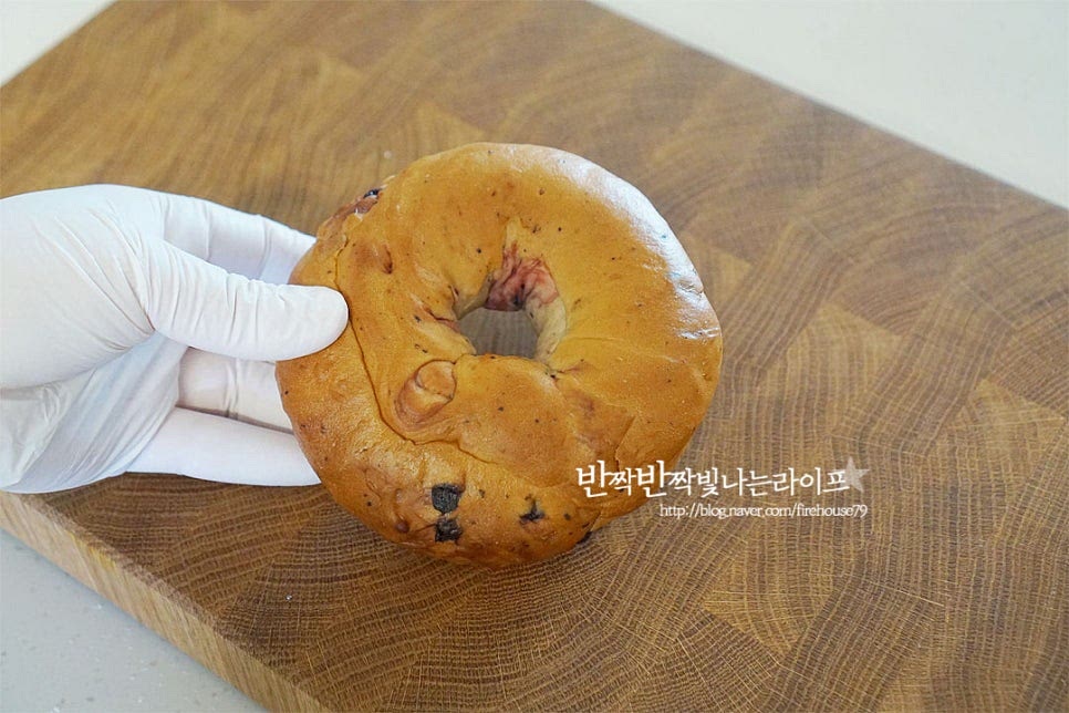 쫄깃한 식감에 손이 가는 베이글은 첨가하는 재료에 따라 플레인에서부터 통밀, 블루베리, 치즈 등 여러 가지 맛이 있죠. 새콤달콤한 과일이 들어간 블루베리베이글을 준비했어요. 단면을 반으로 잘라준 뒤 구워줄 것이에요. 빵칼을 넣고 잘라줍니다. 에어프라이어 트레이에 넣고 베이글굽기 해줍니다. 그대로 먹어도 쫀득쫀득 맛이 좋지만 구워서 먹음 겉이 바삭하면서 따뜻하고 속이 쫄깃해지는 식감이 더 맛이 좋아요. 베이글 에어프라이어는 180도 5분 구워주는데요. 냉동이라면 시간을 추가해 주고, 기기의 사양에 따라 시간과 온도는 조절해 줍니다. 반으로 잘라주었기 때문에 5분 이내로 구워주면 겉과 속이 따뜻하게 구워져요. 빵 굽는 냄새가 고소해요. 냉동소분해둘 때 반으로 잘라두면 하나씩 꺼내어 구워 먹기 좋아요. 노릇노릇 먹음직스럽게 구워졌어요.