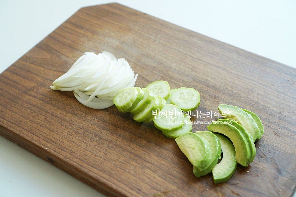 양파는 얇게 슬라이스한 뒤 매운맛을 빼고 아삭한 식감을 살리기 위해 찬물에 담갔다 물기를 털어줍니다. 아보카도는 가운데 씨를 제거한 뒤 슬라이스하여 줍니다. 오이는 얇게 슬라이스한 뒤 소금 1/3 작은 술을 뿌려 5분 정도 절여 물기를 제거해요. 당근 역시 얇게 썬 뒤 소금 간하여 오이와 같이 재워줍니다. 어린잎 채소는 씻은 뒤 물기를 완전히 털어주고, 방울토마토는 반으로 잘라줍니다. 곁들이는 채소는 다양하게 준비해 주시면 푸짐하고 건강하게 드실 수 있어요.