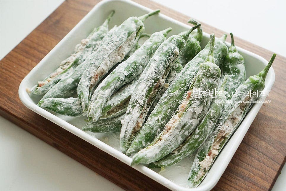 밀가루를 가볍게 묻혀 튀김옷이 잘 어우러지도록 해줍니다. 반죽을 얇게 입혀주고요~ 팬에 식용유를 넉넉히 넣고 170도로 달구어 줍니다. 반죽을 떨어뜨려보았을 때 파르르 떠오르면 됩니다. 고추를 하나씩 넣어가며 튀겨줍니다. 한 번 튀겨주고 건져 낸 뒤 식용유를 정돈하고 한번 더 두 번 튀겨주어 식감을 살려주었어요^^ 갓 튀겨서 뜨거울 때 호호 불어서 먹음 얼마나 별미인지 몰라요. 겉은 바삭바삭 속은 고기소의 육즙과 감칠맛이 촉촉 튀기면 배로 맛나죠^^ 요리 영상을 같이 보시면 보다 쉽게 만들어 드실 수 있답니다. 당면이 들어가서 중간중간 식감도 좋고 마치 고추로 만든 만두를 먹는 맛이에요. 고추튀김 만드는법 고기소를 가득 넣어 감칠맛도 살리고 바삭바삭 식감 살려 맛있게 만들어 드세요^^ 끄읕 !