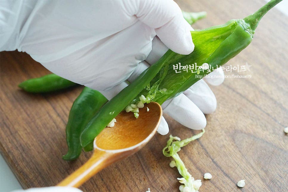 아삭이고추는 가운데 칼집을 낸 뒤 씨를 제거하여 줍니다. 특유의 고추향을 살리고 싶다면 씨를 제거하지 않으셔도 되고요. 꼭지 부분도 정돈하고, 가운데 씨를 제거하여 준비했어요. 소를 채워 넣기 전에 밀가루를 골고루 발라줍니다. 그래야 속 재료가 따로 놀지 않고 조화롭게 어우러집니다~ 안쪽으로 소를 채워 넣어요. 너무 많이 모양이 터질 수도 있으니 안에 빈 공간에 가득 채워줍니다.