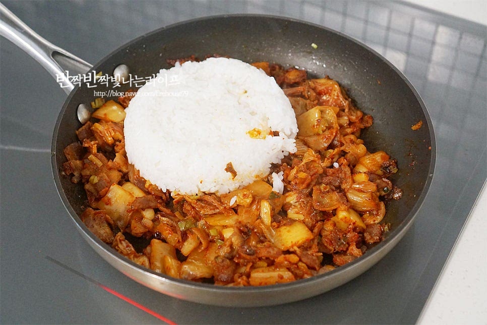 재료들이 충분하게 익으면 식힌 밥을 넣어줍니다. 밥알에 간이 잘 스며들도록 요리하기 위해 뜨겁거나 진밥이 아닌 고슬고슬 한 김 식힌 밥을 넣어주면 그 사이로 양념이 배서 한 알 한 알 먹는 맛이 있어요. 덩어리지지 않도록 잘 풀어가며 볶아줍니다. 참기름 1 큰 술, 통깨 약간 뿌려 마무리 완성하여 줍니다.