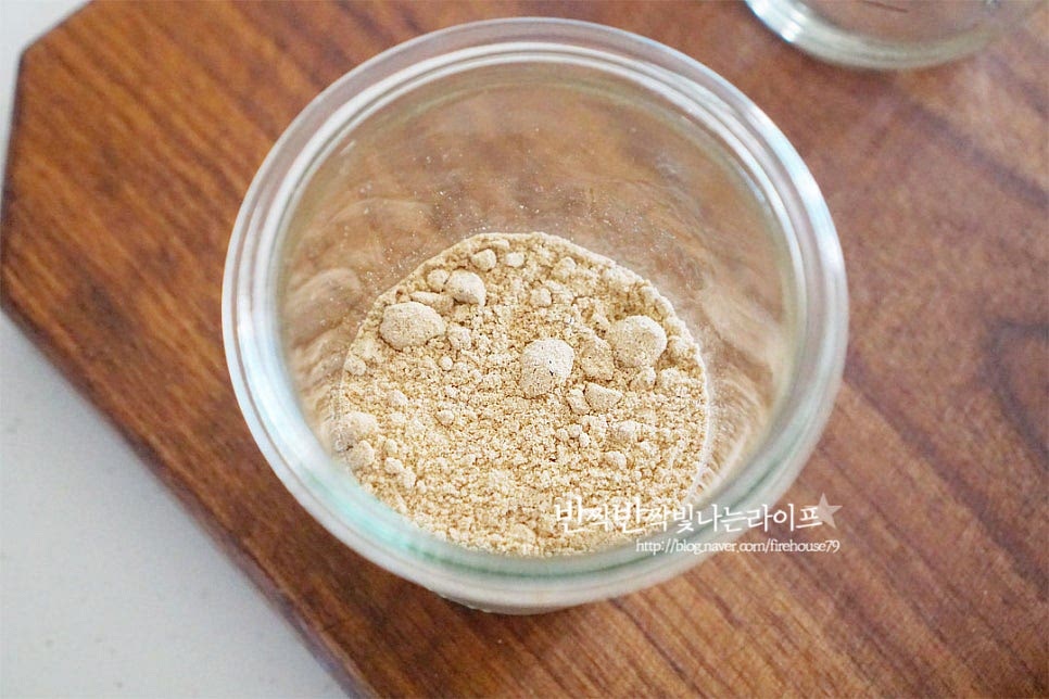 7가지 곡물이 들어간 미숫가루에요. 들어가는 것에 따라 색의 진하기와 맛은 차이가 있는데요. 그렇기 때문에 타는법 비율이 딱 정해져있다기보다 조절하여 만들기 하면 됩니다. 미숫가루 타는법은 덩어리 지지않게 골고루 섞어주는 것이 중요한데요. 대접이나 컵에 바로 섞어서 드셔도 되지만 쉐이커를 활용하면 섞기 편합니다. 먼저 4 큰 술 듬뿍 넣어주었습니다. 얼음컵에 시원하게 타서 먹을 것이라 농도를 진하고 되직하게 만들어 주었어요. 그리고 설탕 2 큰 술 가까이 넣고 가볍게 섞어줍니다. 액체류를 넣기 전에 설탕과 먼저 섞어주시면 더 곱게 잘 풀어집니다. 앞서 말씀드린 것과 같이 설탕 대신 다양한 단맛을 넣어도 좋은데요. 당도에 따라 가감해 주시면 됩니다. 옛날 스타일로 드시고 싶다면 물 + 설탕으로 타주면 됩니다.