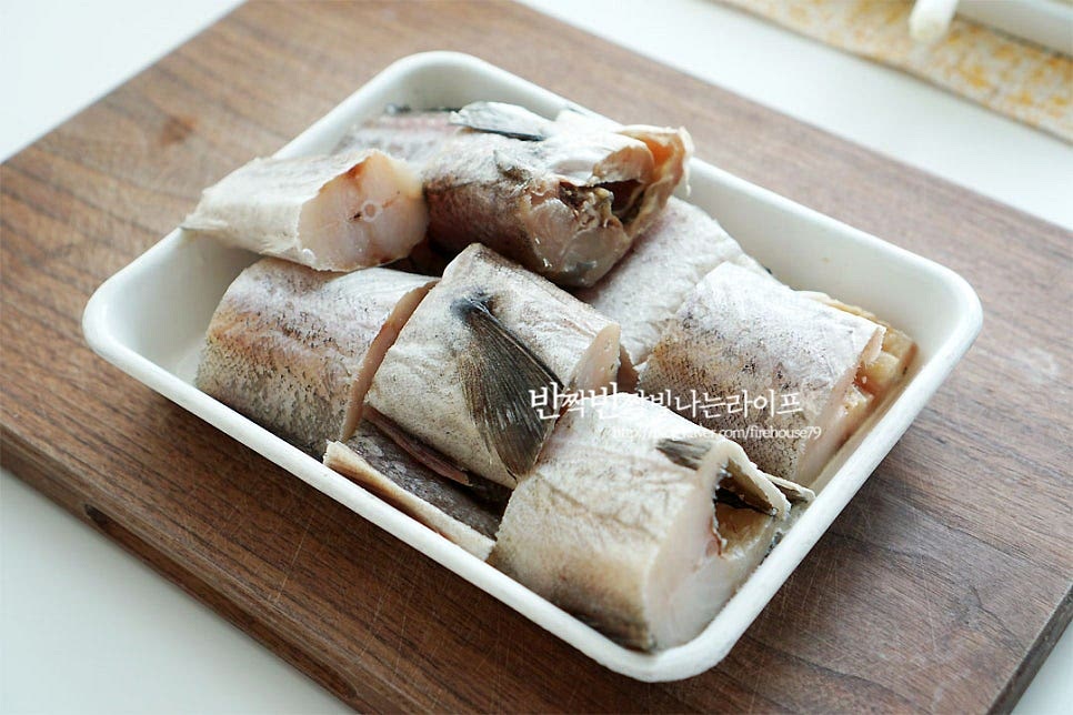 얼려진 생선은 찬물로 가볍게 헹구어 줍니다. 토막으로 손질된 것을 준비했어요. 보통 시장이나 마트에 가면 손질해 준답니다. 몸통 토막만 준비하였는데 머리나 알 또니 고니가 들어가면 더 깊은 맛을 끓일 수 있어요. 비늘이 있다면 칼로 긁어 제거하고, 지느러미 부분은 가위로 잘라줍니다. 몸통 안에 내장을 깨끗하게 손질하여 주어야 비린내를 잡을 수 있어요. 흐르는 물에 씻어 안까지 손질해 줍니다. 무는 나박하게 썰어줍니다. 동태탕을 끓일 때 무가 들어가면 시~원함이 더 맛있어요. 양파는 채 썰고, 대파와 고추는 어슷 썰어 줍니다. 매운맛을 좋아하는 기호에 따라 고 추양은 가감하여 줍니다. 두부는 먹기 좋게 썰어 준비해요.