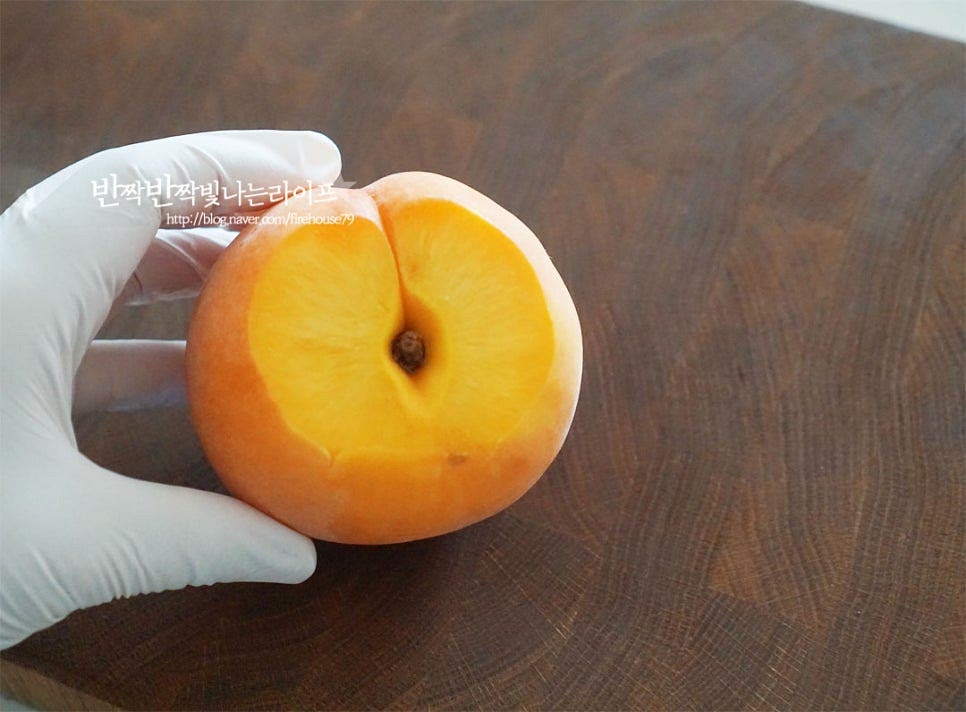 물기를 제거한 복숭아는 꼭지 부분을 조금 잘라내어 평평하게 해줍니다. 그럼 씨를 제거하기도 수월하고 접시 위에 올려서 먹기에 고정하기도 쉽습니다. 꼭지부분 주변으로 동그랗게 칼집을 넣어줍니다. 너무 깊이 넣어도 과육이 잘릴 수 있으니 천천이 돌려가며 가운데 씨부분을 중심으로 칼집 넣어요. 크기가 작은 숟가락을 준비한 뒤 동그란 칼집 부분을 따라 살짝 돌려서 씨를 빼내어줍니다. 천천히 스푼을 움직여가며 살짝 비틀어 씨를 제거했습니다. 가운데 속 부분의 과육과 과즙을 정돈하여 그릭요거트를 채울 수 있도록 해줍니다.