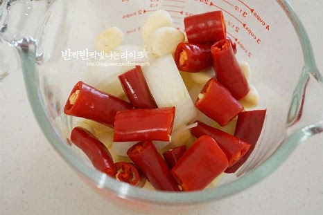 갈아줄 재료들을 볼에 담아줍니다. 홍고추 5개, 사과 1/2개 양파 1/2개, 통마늘 10알 새우젓 1 큰 술, 매실액 2 큰 술 생강 마늘 1/2알 크기 1개를 넣어줍니다. 블렌더 또는 믹서기로 갈아줍니다. 사과와 매실액이 들어가 은은한 단맛을 내었습니다. 사과 대신 배를 갈아도 좋습니다. 간 재료에 고춧가루 7 큰 술, 찹쌀풀, 액젓 6 큰 술을 넣어줍니다. 간을 보도 입맛에 맞게 짠맛과 단맛은 조절해 주세요. 액젓은 꽃게액젓을 넣었습니다.