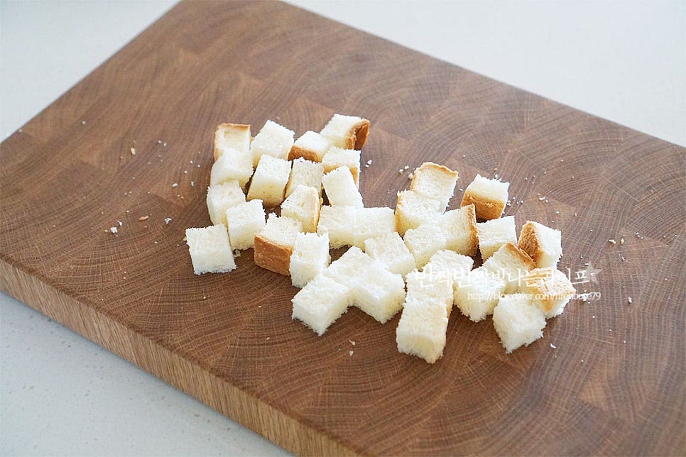 시저샐러드에 빠질 수 없는 것이 바로 크루통인데요. 식빵을 네모나게 잘라 바삭하게 구워줄 것이랍니다. 식빵은 사방 1cm 두께로 잘라줍니다. 달군 팬에 버터 1 큰 술을 녹인 뒤 자른 식빵을 구워줍니다. 겉면이 바삭하게 구워지면 파르메산치즈가루 1 큰 술, 파슬리가루 약간 후추 약간 뿌려 골고루 어우러지도록 구워줍니다. 타지 않도록 중약불에서 수분을 날려 노릇하고 바삭하게 구워준 뒤 눅눅해지지 않게 채망에 올려 열기를 식혀줍니다.