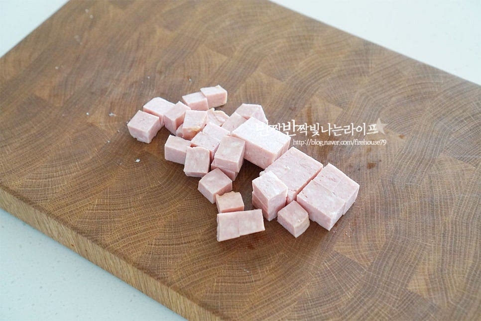 통조림 햄은 대략 100g 정도 준비해주었는데요. 통조림에 든 네모햄 종류는 입맛에 맞게 준비하고 짠맛을 줄이고 싶다면 라이트로 요리해주세요. 저는 라이트 스팸을 준비했습니다. 한입에 먹기 좋도록 깍둑썰기해줍니다. 너무 작지 않게 적당히 큼직하게 자르면 겉은 바삭하고 속은 촉촉한 식감으로 맛볼 수 있어요. 바로 썰어주셔도 좋고, 뜨거운 물을 부어 불순물을 한번 제거해 주셔도 좋아요. 달군 팬에 스팸을 올리고 뒤집어가며 겉을 노릇하게 구워줍니다. 재료에서 기름이 나오기 때문에 따로 기름을 두를 필요는 없습니다. 겉을 바삭하게 구워주면 바삭 촉촉하고 고소한 풍미를 맛볼 수 있습니다.