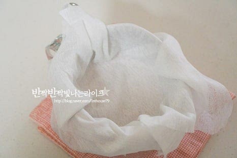 몽글몽글 끓여지면 체 위에 면포를 깔고 끓인 우유 치즈를 부어줍니다. 수분을 어느 정도 빼고 식힌 뒤 주머니 모양으로 끈으로 묶어 고정해 냉장고에서 수분을 빼줍니다. 반나절 이상 두면 수분이 빠지고 질감이 꾸덕꾸덕 진해집니다. 입맛에 따라 부드럽게 또는 꾸덕하게 분리해 주세요.