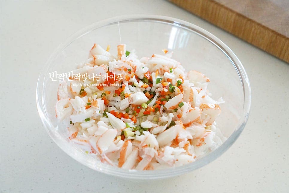 넉넉한 크기의 볼에 손질한 재료를 넣어줍니다. 계란 2개를 넣어줍니다. 팽이버섯에 계란만 넣고 전을 구워도 별미로 두 가지 재료의 맛이 잘 어울려요. 감칠맛 살려줄 참치액 1 작은 술과 소금, 후추 약간으로 간을 하고 부침가루 1 큰 술을 더해 농도를 조절해 줍니다. 부침가루나 밀가루가 들어가면 팽이버섯전 모양을 내기 좋습니다. 소량의 참치액이나 액젓, 국간장을 넣어주면 깊은 맛을 더해주는데요. 짜지 않게 간을 해주고 구운 뒤 케첩이나 소스를 곁들여도 좋아요. 모든 재료를 넣고 골고루 섞어줍니다. 서로 어우러질 수 있도록 반죽해 주세요.