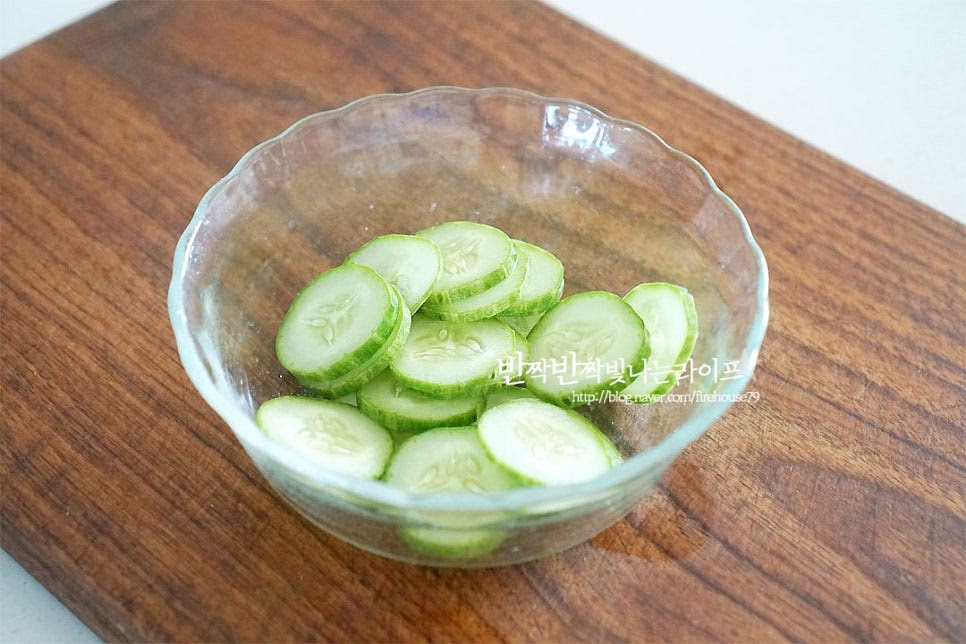 곁들일 채소를 손질하여 줍니다. 오이는 얇게 슬라이스한 뒤 소금 1/4 작은 술 넣고 10분 정도 둔 뒤 수분이 나오면 면포로 짜줍니다. 양파는 얇게 슬라이스하고 방울토마토는 반으로 자르고 콘 옥수수는 물기를 털어줍니다. 후숙되어 먹기 좋은 아보카도는 반으로 잘라 씨와 껍질을 제거해요. 잘 익으면 씨와 껍질 분리가 잘 되어요. 먹기 좋게 슬라이스하고, 크래미도 곁대로 찢어 준비해요.