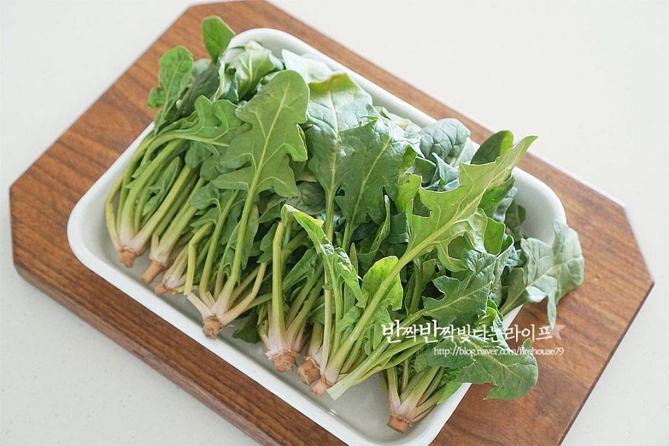 무침을 할 때는 길이가 짧고 뿌리 부분이 붉은빛을 띠는 게 좋아요. 보통 남해초나 포항초가 단맛이 강하고 길이가 짧은 편이더라고요. 누렇게 든 잎은 떼어내어 줍니다. 취향에 따라서 뿌리를 잘라내어도 좋지만 영양이 풍부하고 달큰하여 겉 부분의 흙을 칼로 살살 긁어내어 다듬어준 뒤 먹기 좋게 뿌리 부분을 나누어 줍니다. 연결 부분에 흙이 묻어나니 더 꼼꼼하게 긁어줍니다. 사이사이 흙을 깨끗하게 씻어 체에 밭쳐 물기를 털어줍니다. 끓는 물 1L에 소금 1/2 큰 술을 넣어줍니다. 팔팔 끓을 때 넣고 숨이 죽으면 건져내면 되는데요. 너무 오래 데치면 물러지기 쉬워 크기와 양에 따라 15~20초 정도 데쳐줍니다. 20초 정도 데쳐준 뒤 바로 건져내어 찬물에 헹구어 물기를 꼭 짜줍니다.