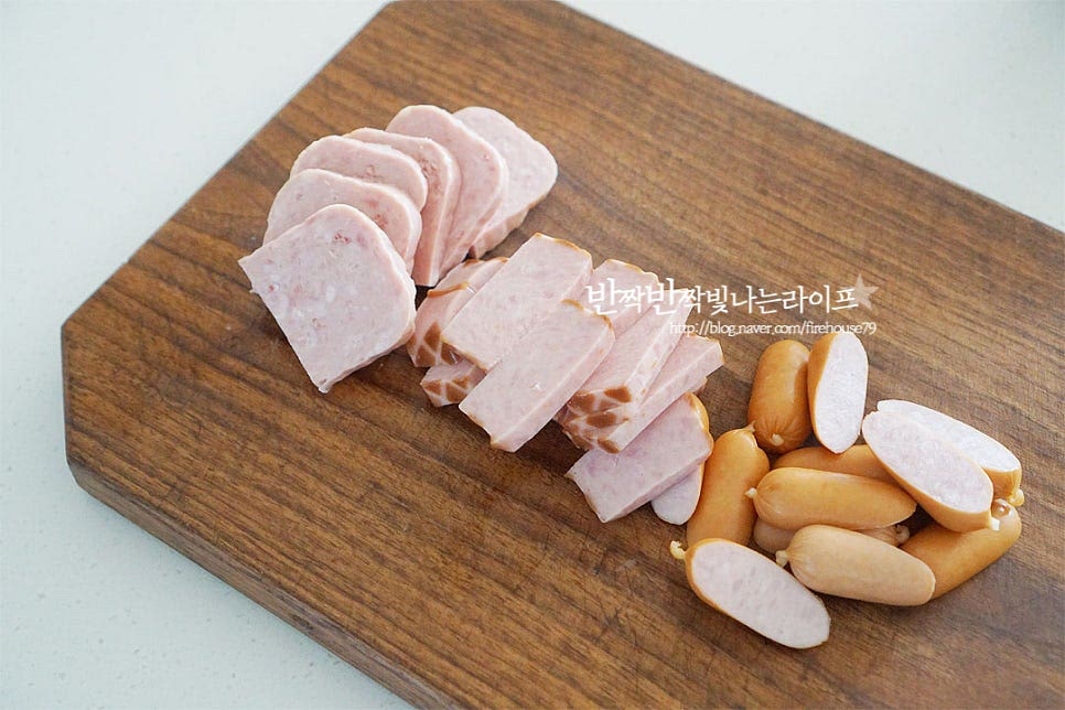 부대찌개에 햄은 다양하게 넣을수록 특유의 국물 맛이 더 풍부해지는데요. 저는 통조림, 스모크, 비엔나 세 종류를 넣고 끓였어요. 그 외 베이컨을 넣어도 좋아요. 네모난 햄들은 집어먹기 좋게 슬라이스하고, 비엔나는 대각선으로 어슷하게 썰었어요. 햄을 그대로 넣으셔도 좋고 기름기를 제거하여 깔끔하게 드시고 싶다면 체에 밭쳐 끓는 물을 부어주세요.