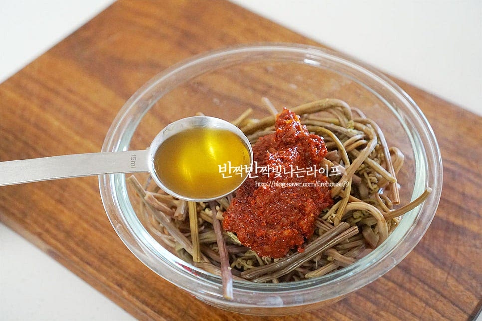 고사리는 먼저 양념에 버무려 밑간하여 끓여줄 것이에요. 간이 맛있게 스며든답니다. 앞서 만들어둔 양념장 1/2분량과 들기름 1 큰 술 넣고 조물조물 버무려 줍니다.