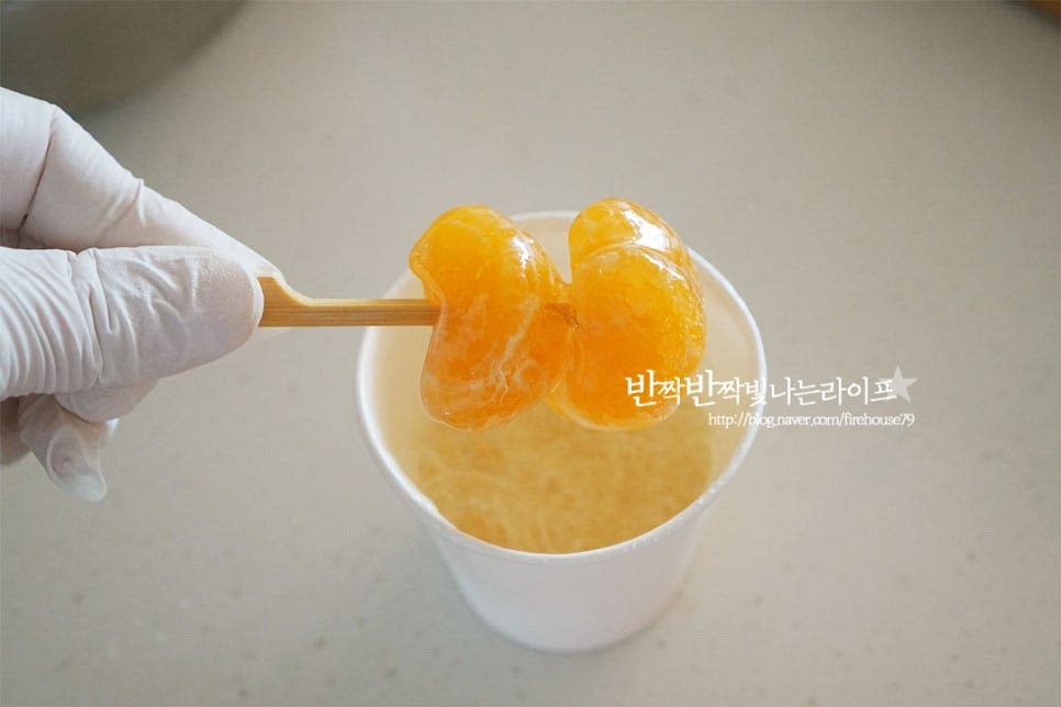 지금부터는 굳지 않도록 빠르게 작업해 줍니다. 시럽에 담가 골고루 입혀주어요. 뜨거우니 조심해 주세요. 매끈하게 코팅해 준 뒤 얼음물에 바로 담가 굳혀 꺼내어줍니다. 수분에 오래 닿으면 녹을 수 있기 때문에 바로 굳혀서 물기를 털어주세요. 담가놓으면 녹을 수 있습니다. 뜨거웠던 귤이 차가운 얼음물에서 나와 바삭바삭 식감이 있는 사탕으로 바뀌었어요. 이 과정을 반복해 여러 개 만들어 줍니다. 귤 탕후루 만들기 과정은 글로만 보면 간단해 보이지만 생각보다 실패하시는 분들이 많더라고요. 충분하게 노란빛이 돌도록 끓여주는 것, 녹인 뒤 부터는 빠르게 작업하여 굳혀주는 것, 뜨거우니 조심해 주는 것이 중요합니다. 전자렌지로 만들 땐 한 번에 녹이면 넘치거나 농도를 보기 어려우니 나누어서 조리해 주고요. 영상도 같이 담았어요. 누구나 좋아하는 달콤한 간식으로 식감과 달콤한 맛에 찾게 된답니다. 먼저 알려드린 몇 가지 팁을 참고하시면 맛나게 즐길 수 있답니다. 귤 탕후루 만드는법 겉은 바삭바삭하고 속은 새콤달콤함이 가득한 맛 실패없이 맛있게 만들어 드세요^^ 끄읕 !